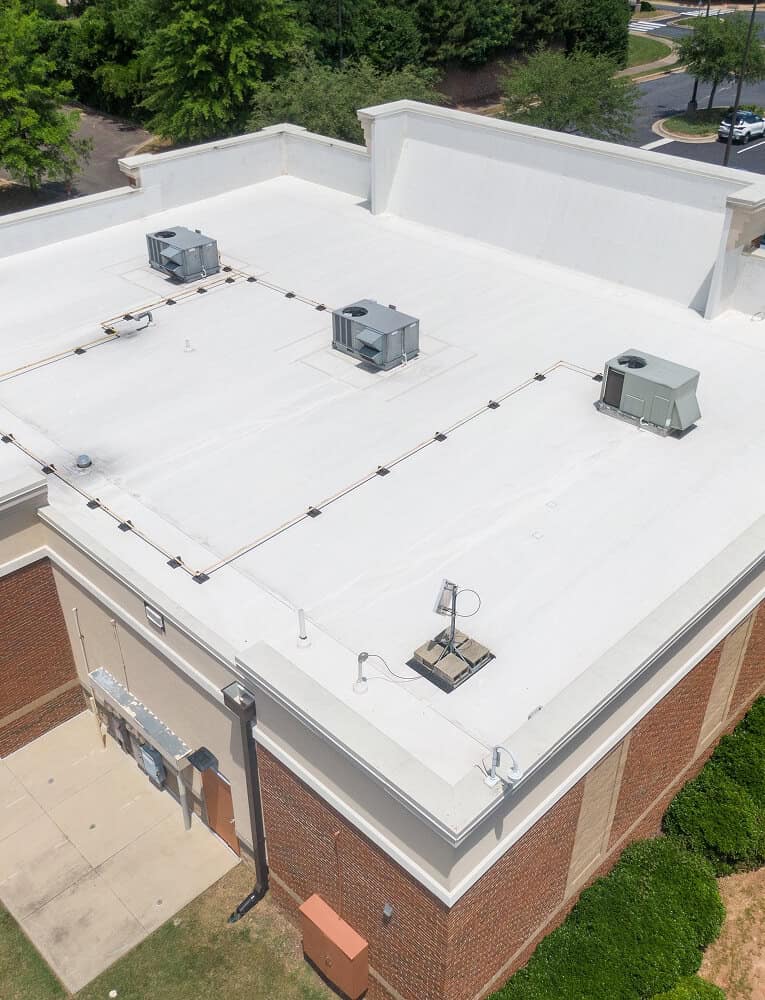 Aerial view of a commercial flat roof with HVAC units, highlighting flat roof restoration and commercial roofing maintenance.
