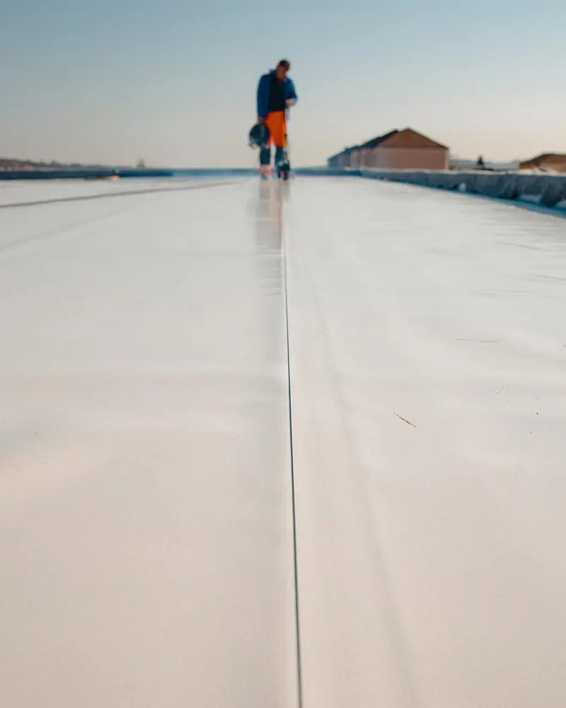 Individual blurred on a commercial flat roof, showcasing roof repair and restoration.