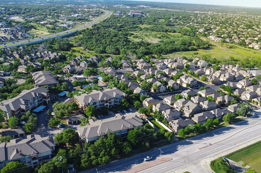 Aerial view showing commercial buildings with flat roofs and roof restoration work.